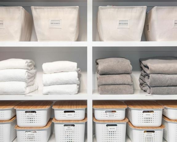 Ropa de cama y toallas organizadas en estantes de cajas.