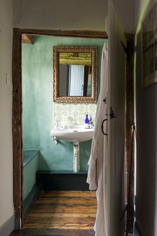 白いシンクと鏡付きのヴィンテージブルーのバスルーム