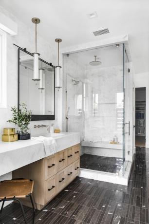 bagno in marmo con doccia a parete piastrellata in marmo, pavimento in marmo scuro, box doccia, lavabo in marmo di legno