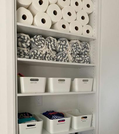 Hârtie igienică organizată și lenjerie de pat în spațiul de debara