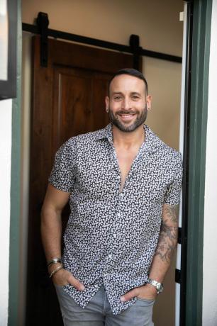 Carmine Sabatella stovi žaliose duryse su raštuotais marškiniais