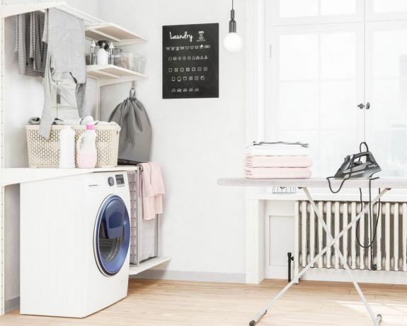 πώς να πλένετε τα ρούχα στο χέρι - ένα δωμάτιο πλυντηρίου με σιδερώστρα και πλυντήριο ρούχων - GettyImages -1097712510