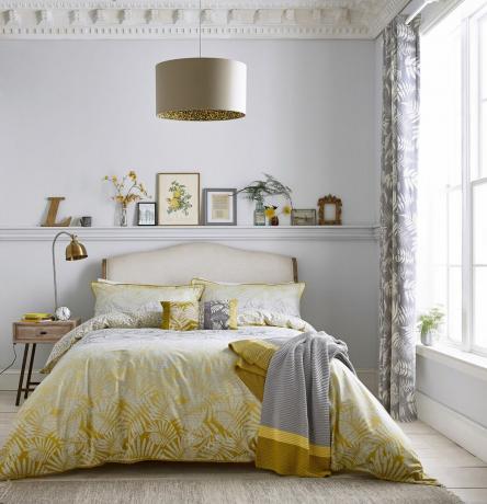 クラリッサハルスの黄色い寝具とグレーのスローのベッドルーム