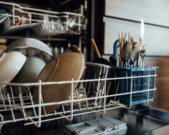 машина за прање судова спремна за пражњење са прибором за јело и тањирима