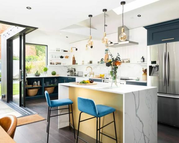 Eine moderne Küche mit Wannendecke, offenem Grundriss und Kücheninsel aus Marmor