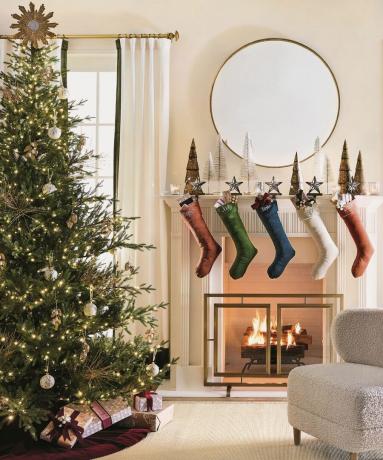مدفأة عيد الميلاد مع غابة شجرة فرشاة الزجاجة ، جوارب شخصية ومرآة حائط مستديرة