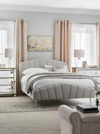 dormitorio gris y ruborizado con cama curvilínea y muebles con espejos, alfombra gris