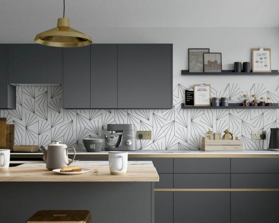 g -formet kjøkken med grå skap, svart -hvitt flislagt bakside og benkeplater i tre