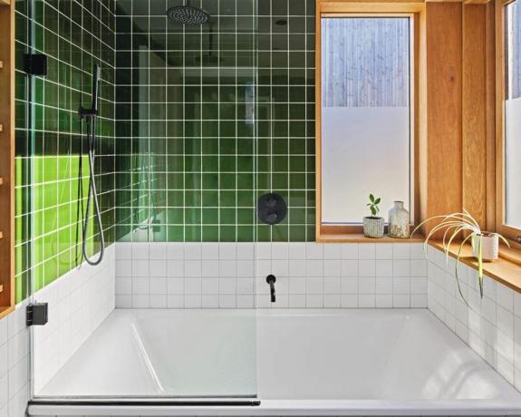 Eine Badewanne mit grünen und weißen geometrischen quadratischen Fliesen