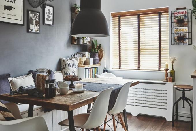 Обеденный гарнитур со стульями в стиле Eames в кухне-столовой открытой планировки в стиле скандинавской кухни.
