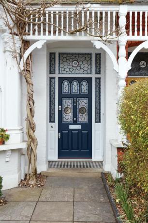 Puerta de entrada victoriana azul con paneles acristalados