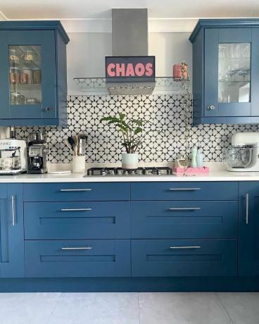 Et blått kjøkken med avtrekksvifte med klistremerker på