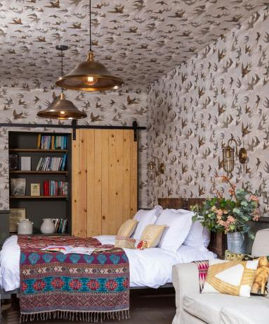 Duvarlarda ve tavanda kuş motifli duvar kağıdı bulunan rahat yatak odası
