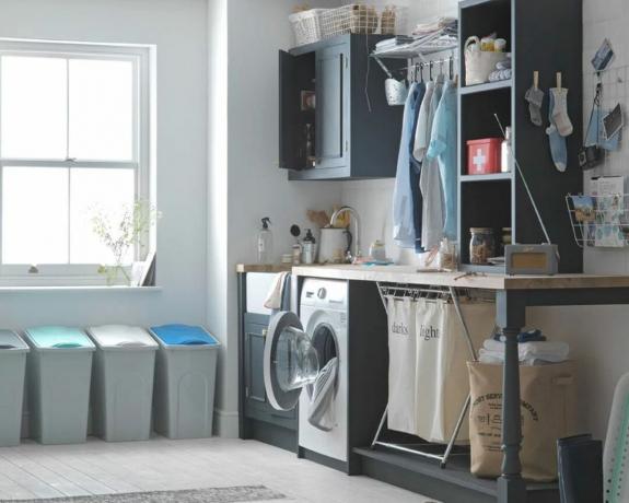 et vaskerom med oppbevaring, vaskemaskin og et vindu av argos