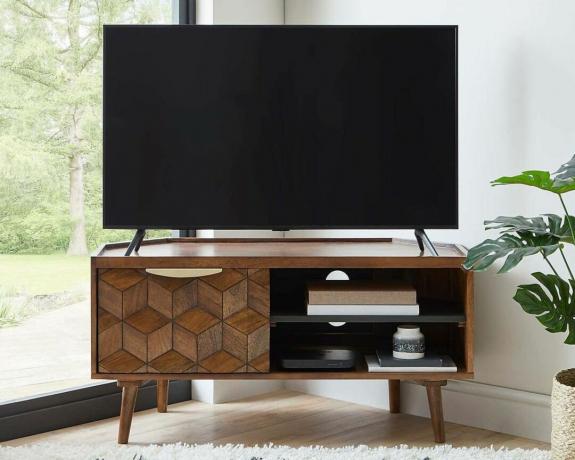 Hex hjørne tv -stativ i hvid stue ved siden af ​​anlægget med tv oven på