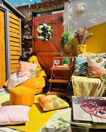 Uteplats med gula väggar och möbler