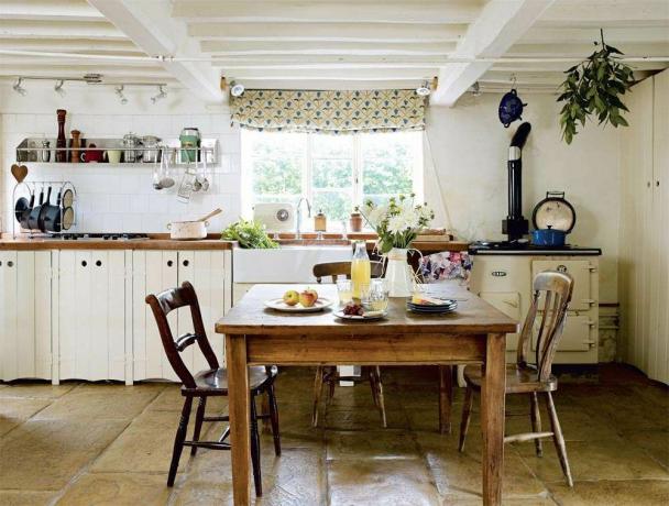 Cucina in un cottage in legno con travi a vista bianche