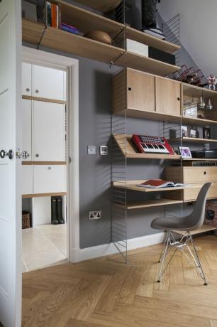 estante aberta de madeira, mesa e espaço de escritório