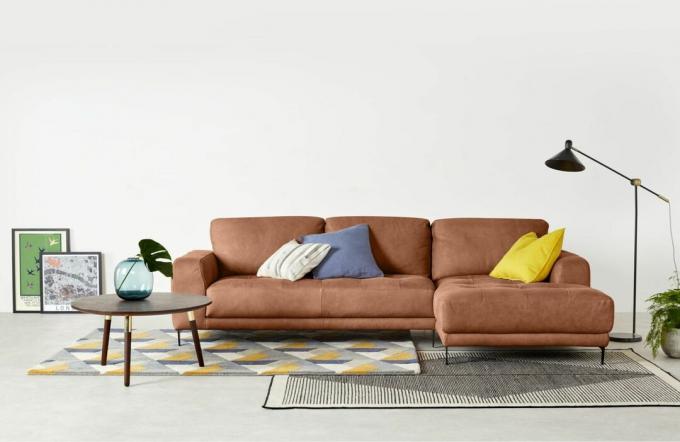 Un divano chaise longue in pelle marrone chiaro in un salotto moderno
