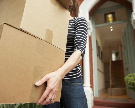 femeie care transporta cutii în mișcare din casă