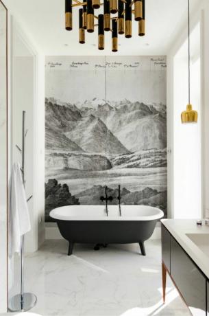 Bijela kupaonica sa centralnim zidnim pejzažom od drvenog ugljena, crno obojenom samostojećom kadom i zlatnim akcentima