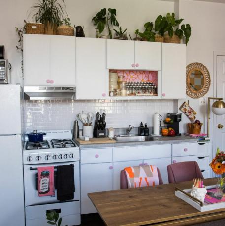 Maža rožinė ir balta buto virtuvė