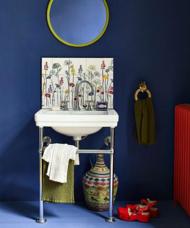 Kobaltno plava kupaonica s cvjetnim pločicama za sudoper i naglascima u svijetlim bojama