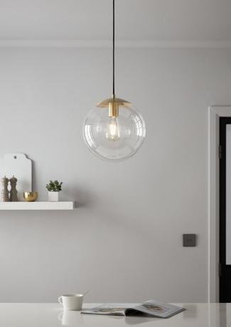 ronde glazen hanglamp boven eettafel, geheel wit schema