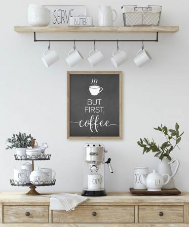Mielas kavos baro išdėstymas su įrėmintu tipografijos atspaudu ant sienos