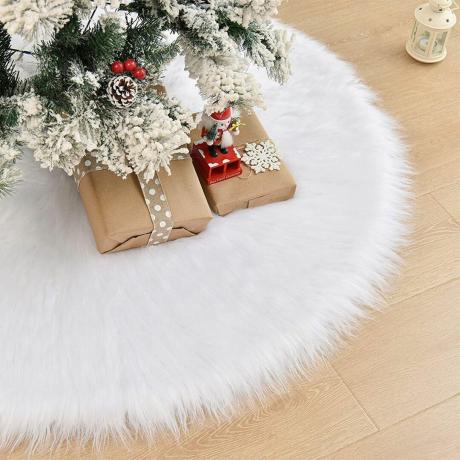 กระโปรงต้นคริสต์มาส WEYON ขนเทียมสีขาวอยู่ใต้ต้นไม้พร้อมของขวัญอยู่ด้านบน