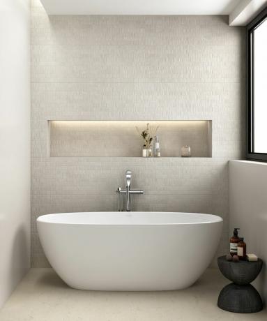 Kis fehér fürdőkád texturált falháttérrel és megvilágított fülkével
