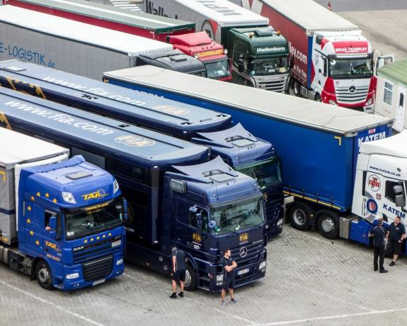 Britanski vozači kamiona čekaju ispred kamiona na parkiralištu