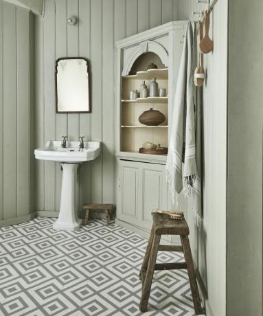 Biela stena obložená kúpeľňa s bielym umývadlom, drevenými stoličkami a kúpeľňovou skrinkou od spoločnosti Carpetright