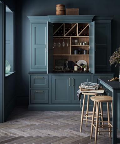 Tamsi ir nuotaikinga virtuvė su Baltic Green sandėliuko spintele ir tamsiai dažytomis sienomis