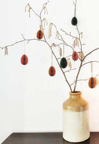 un jarrón con un árbol de pascua con decoraciones de huevos de pascua de papel