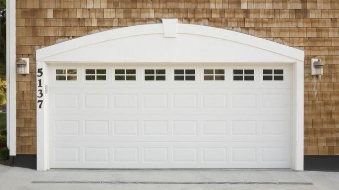 Puerta de garaje blanca en una casa de tejas