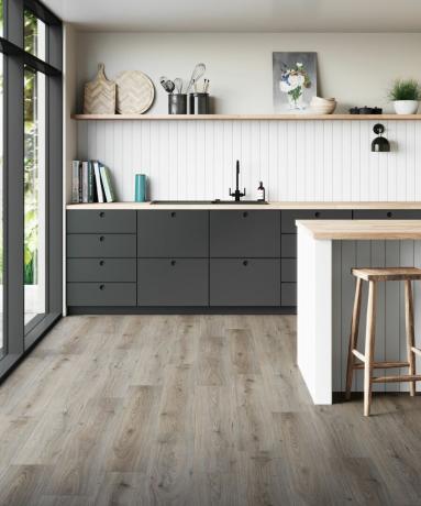 Una cocina moderna con una decoración neutra y suelo laminado gris