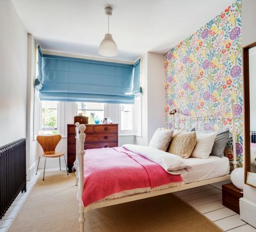 ห้องนอนที่มีผนังและผ้าปูที่นอนสีชมพู ถ่ายโดย Bruce Hemming