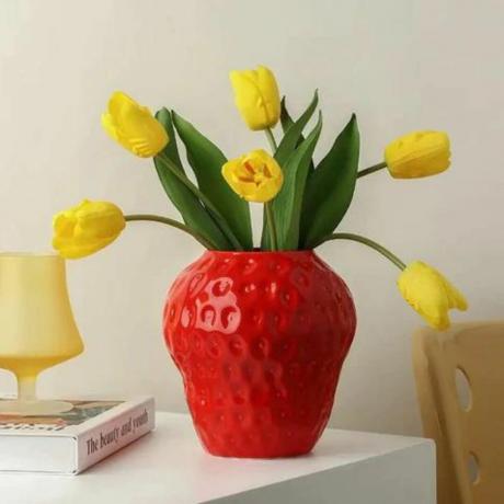 Czerwony wazon truskawkowy z jasnożółtymi tulipanami 