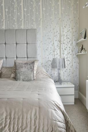 camera da letto neutra con carta da parati metallica ad albero e accessori argento