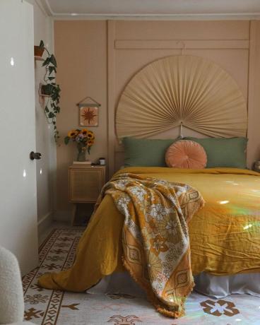 Accogliente camera da letto boho con pareti color albicocca, morbida biancheria da letto e federe per cuscini
