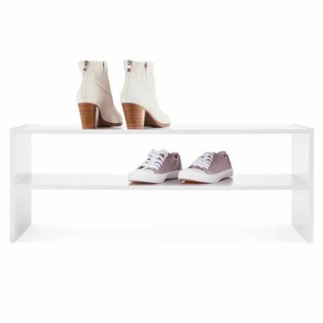 Auf einem weißen Regal mit drei Ablageflächen stehen zwei Paar Schuhe