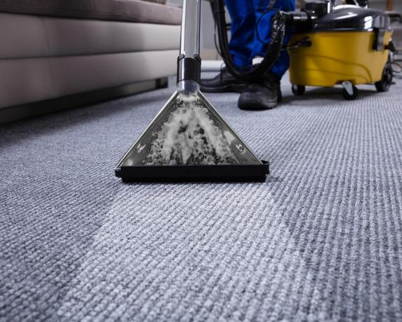 Um caroet texturizado sendo limpo com um limpador de carpete profissional