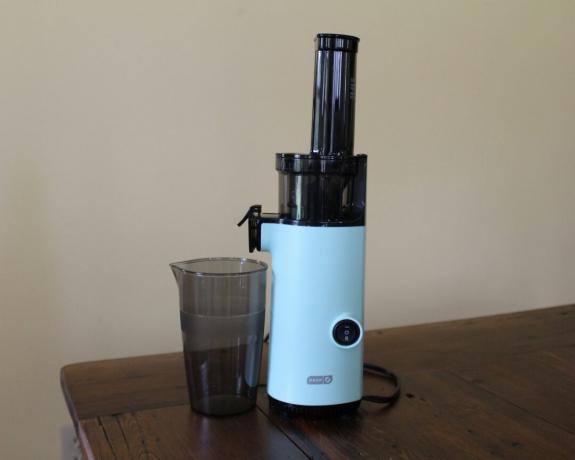Dash Compact Juicer in Aqua auf dunklem Holztisch