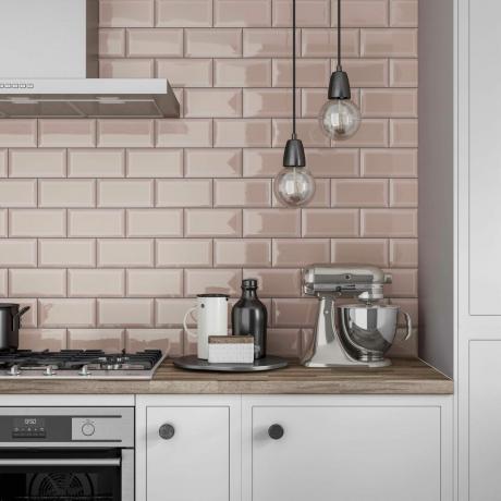 светло-розовая глянцевая плитка метро в белой кухне с деревянной столешницей