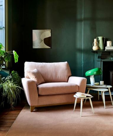 poltrona rosa e tappeto nel soggiorno verde