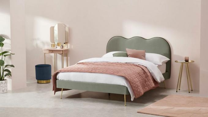 Dokonano sprzedaży: podwójne łóżko Fenella w jasnej sypialni z różową pościelą obok stolika nocnego i toaletki