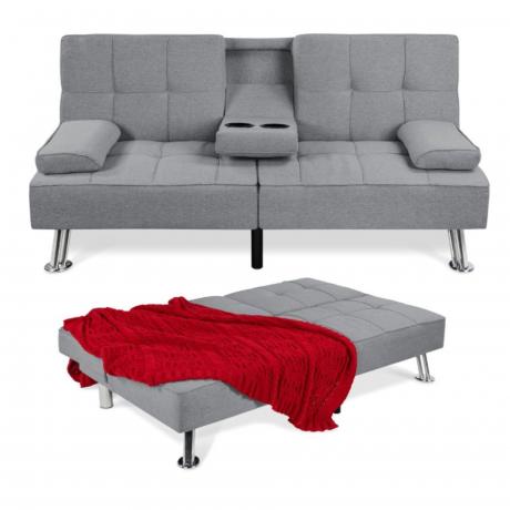 En tvåsits grå soffa med en utfälld säng framför