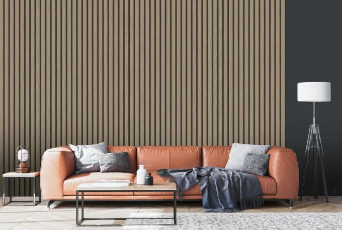 ورق حائط بتأثير Slat في صالة مستوحاة من السبعينيات مع أريكة جلدية ووسادة رمادية وسجادة كبيرة المساحة