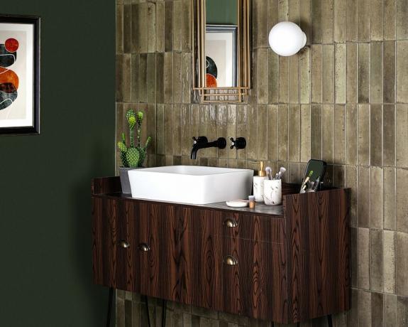 მინკვის კრამიტით დაფარული კედელი სარკით და ყავისფერი აბაზანის შესანახი ერთეული კედლებითა და იატაკით